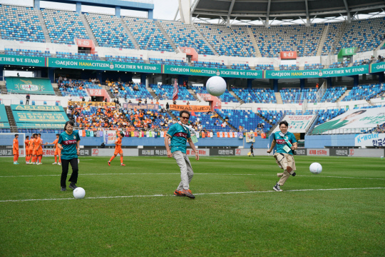 국가연구소 대학인 과학기술연합대학원대학교(UST)은 지난 8일 설립 20주년을 맞아 대전 월드컵경기장에서 'UST 브랜드데이'를 열고 경기장을 찾은 시민을 대상으로 학교 홍보에 나섰다.   사진은 대전 하나시티즌 축구 경기에 앞서 김이환 UST 총장(가운데), 황정아 천문연 스쿨 대표 교수(왼쪽), 변지철 UST 총학생회장이 시축을 하고 있다. UST 제공
